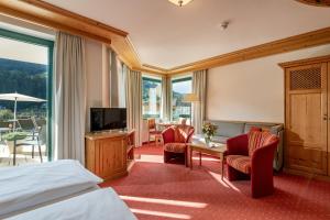 a hotel room with a bed and a television at Hotel Elisabeth, 4 Sterne Superior in Kirchberg in Tirol