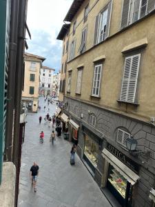a group of people walking down a street with buildings at Lucca Charm in Lucca