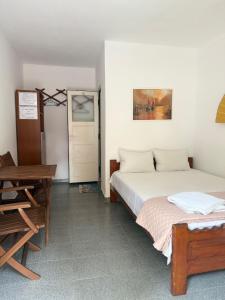 a bedroom with two beds and a table and a desk at Casa Ghemus Costinesti in Costinesti