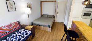 a small room with a bed and a couch and a table at Appartement Deauville Plage Front de mer in Deauville +13 photos