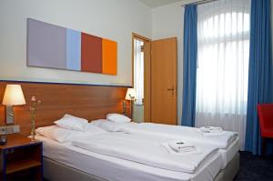 En eller flere senger på et rom på Hotel & Apartments Fürstenhof am Bauhaus