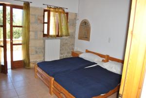 a bedroom with a blue bed and a window at Armonia in Stoupa