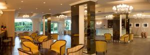 a dining room with chairs and a table and a bar at Hotel Caparena in Taormina