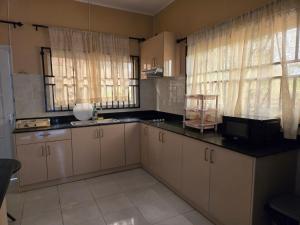 a kitchen with white cabinets and black counter tops at Southview Residence in Meerzorg