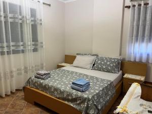 a small bedroom with a bed and curtains at Golem, Mali i Robit in Golem