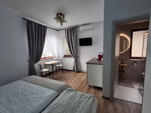 a bedroom with a bed and a desk and a table at Clar Studio Residence in Braşov