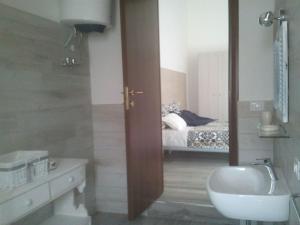 a bathroom with a toilet and a sink and a bed at B&B La Casa Bianca di Porto Conte in Porto Conte