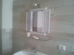 a bathroom with a mirror and a sink at B&B La Casa Bianca di Porto Conte in Porto Conte
