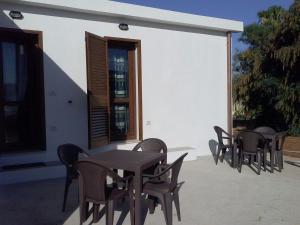 a group of tables and chairs on a patio at B&B La Casa Bianca di Porto Conte in Porto Conte