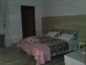 a bedroom with a bed and a ottoman in it at B&B La Casa Bianca di Porto Conte in Porto Conte