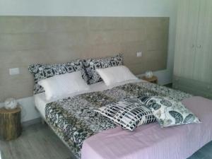 a bedroom with a bed with pillows on it at B&B La Casa Bianca di Porto Conte in Porto Conte