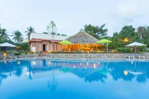 a resort with a large swimming pool with umbrellas at The Garden House Phu Quoc Resort in Phu Quoc