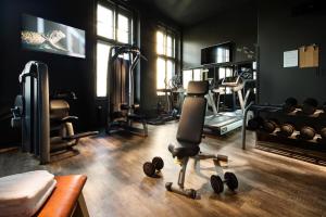 a room with a gym with a chair and weights at pentahotel Braunschweig in Braunschweig