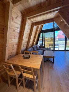a wooden table and chairs in a room with a couch at TriView in Žabljak