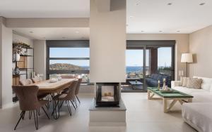 un soggiorno con tavolo e camino di Villa Nefeli Athenian Riviera ad Anávissos