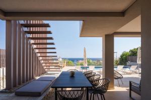 un patio con tavolo e sedie su un balcone di Villa Nefeli Athenian Riviera ad Anávissos