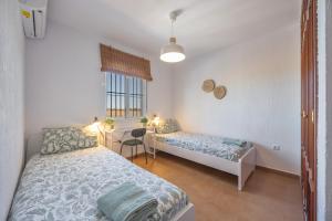 a bedroom with two beds and a desk in it at Villa Mirto Golf in Chiclana de la Frontera +28 photos