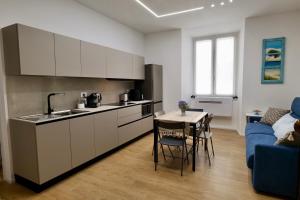 a kitchen and dining room with a table and a couch at ValeVacanze in Savona