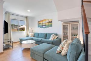 a living room with a blue couch and a table at Villa Mirto Golf in Chiclana de la Frontera