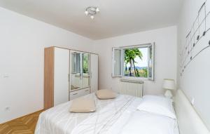 ein weißes Schlafzimmer mit einem Bett und zwei Fenstern in der Unterkunft Villa None Kate by Villas Guide in Dubrovnik + 21 Fotos