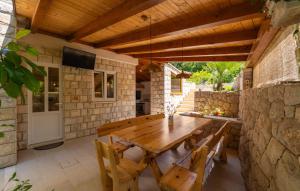 ein Esszimmer mit einem Holztisch und einer Steinmauer in der Unterkunft Villa None Kate by Villas Guide in Dubrovnik
