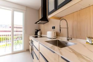 a kitchen with a sink and a large window at Braceli Beach Resort Middle Floor - rentafive in Santa Pola +41 photos