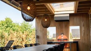 a dining room with a table and chairs and lights at Wellness Villas with sauna, outdoor bath and shower, Parc Maasresidence Thorn in Thorn +27 photos