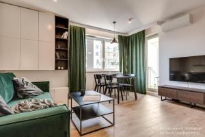 Una sala de estar con un sofá verde y una mesa. en Apartamenty Tespis - Tysiąclecia, en Katowice