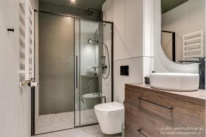 Un baño con ducha, inodoro y lavabo. en Apartamenty Tespis - Tysiąclecia, en Katowice