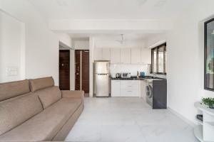 a living room with a couch and a kitchen at Athena 2BHK Khar W by The Bombay Home Company in Mumbai