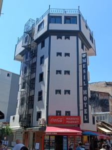イスタンブールにあるMesil Hotelの正面に看板がある背の高い白い建物