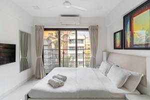 a bedroom with a bed and a large window at Athena 2BHK Khar W by The Bombay Home Company in Mumbai
