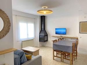 a living room with a stove and a dining room table at Casa Soñiga - Congost de Montrebei in Tolva