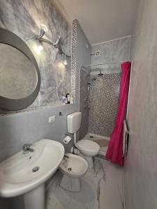 Un baño con lavabo, inodoro y espejo. en B&B Art, en Bussolengo