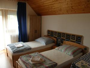 une chambre avec deux lits avec un chapeau dessus dans l'établissement Ilona Vendégház Balatonszabadi, à Balatonszabadi
