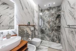 a bathroom with a shower and a toilet and a sink at Volga Promenade Apartment in Durrës