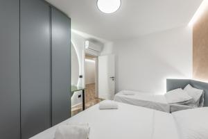 a bedroom with two beds and a mirror at Volga Promenade Apartment in Durrës