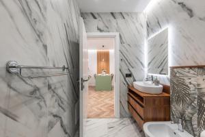 a bathroom with a shower and a sink and a mirror at Volga Promenade Apartment in Durrës