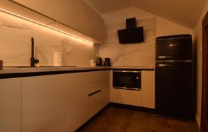 a kitchen with white cabinets and a black refrigerator at Ferienhaus Leticia by Villas Guide in Kraljevica