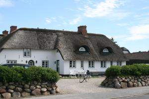 a large white house with a thatched roof at Reetdach Friesenhof Süderende in Westerland (Sylt)
