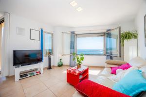 a living room with a couch and a tv at Vista Fábula in S'Illot