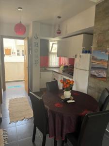a kitchen with a table and chairs and a kitchen with a table and a table at Appartement F2, Perla saidia - plage a 5 min à pieds - Piscine en travaux in Saidia 