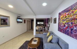 ein Wohnzimmer mit einem blauen Sofa und einem Gemälde an der Wand in der Unterkunft Holiday home Andrea with whirpool by Villas Guide in Opatija