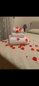 a group of towels and red flowers on a bed at 80vogliadirelax in Rome