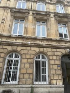 ルーアンにあるCharmant Duplex Rouen Centreの窓とドアのある高いレンガ造りの建物