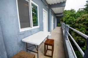 a white bench on a porch with a window at Babosam Transient Dinihill in Boracay