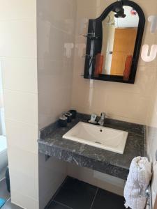a bathroom with a sink and a mirror at Appartement F2, Perla saidia - plage a 5 min à pieds - Piscine en travaux in Saidia  +3 photos