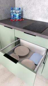 a glass drawer with plates and bottles of water at Apartamenty Piast Myślibórz in Myślibórz +36 photos