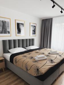 a bedroom with a large bed with two pillows on it at Apartamenty Piast Myślibórz in Myślibórz