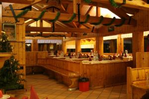 a large wooden restaurant with a bar in the middle at Rifugio Orso Bruno in Commezzadura